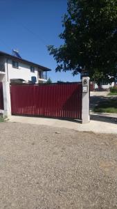 uma cerca vermelha em frente a uma casa em Vila Flight em Aroneanu