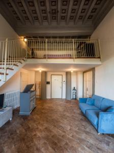 a living room with a blue couch and a staircase at Fabroniana Apartments in Pistoia