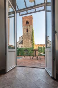 an open door to a patio with a clock tower at Fabroniana Apartments in Pistoia