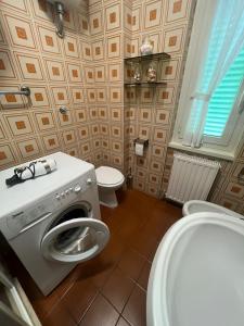 a bathroom with a washing machine and a toilet at Angelucci House in Marina di Cerveteri