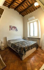a bedroom with a bed in a room with a window at Fabroniana Apartments in Pistoia