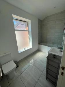 baño con aseo y lavabo y ventana en Dukes Place sleeps 10 comfortably en Wolverhampton