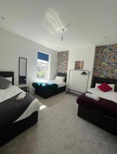 1 dormitorio con 2 camas, sofá y ventana en Dukes Place sleeps 10 comfortably, en Wolverhampton