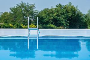 a swimming pool with a chair in the water at I Castagni in Vigevano