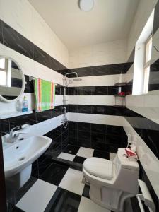 a black and white bathroom with a toilet and a sink at Petra luxurious view house in Wadi Musa