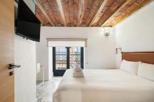 Schlafzimmer mit einem Bett und einem Flachbild-TV in der Unterkunft Nice flat in Lavapiés at street level S23B in Madrid