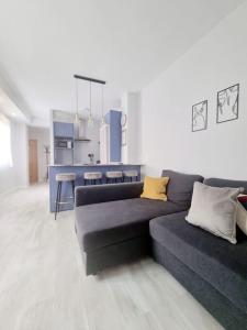 Una sala de estar con un sofá y una cocina. en Increíble Apartamento de lujo en Triana, en Sevilla