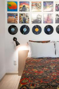 a bedroom with a bed with records on the wall at STUDIOS URCA na rua da mureta da Urca in Rio de Janeiro