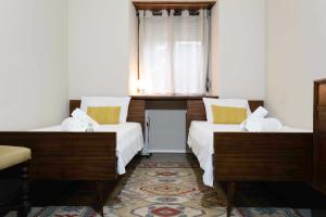 Duas camas num quarto com uma janela em Quinta José&Maria Quartos Ferreira do Zêzere em Ferreira do Zêzere