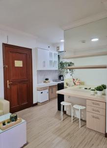 een keuken met witte kasten en een houten deur bij Majesty Apartment 2 Bedroom with City View in Bandung