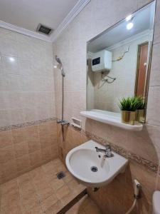 een badkamer met een wastafel en een douche met een spiegel bij Majesty Apartment 2 Bedroom with City View in Bandung