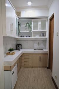 een keuken met witte kasten en een wastafel bij Majesty Apartment 2 Bedroom with City View in Bandung