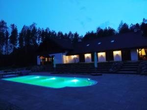 a swimming pool in front of a house at night at Domek przy Majątku Morgi in Suchowola