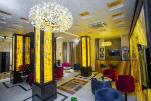 een lobby met rode stoelen en een kroonluchter bij Florence Boutique Hotel by Hotel Pro group in Yakkasaray