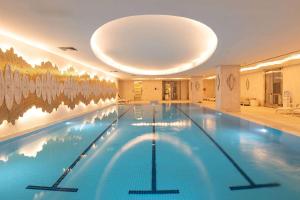 a large swimming pool in a hotel with a ceiling at Wyndham Grand Istanbul Kalamış Marina Hotel in Istanbul