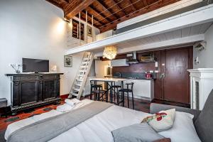 a living room with a large bed and a kitchen at Roommo Studio San Gallo in Florence