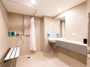 a bathroom with a sink and a shower at Novotel Cairns Oasis Resort in Cairns