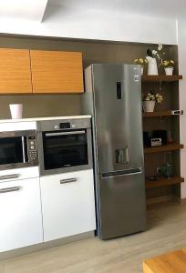 eine Küche mit einem Kühlschrank aus Edelstahl und einer Mikrowelle in der Unterkunft John's house in Rhodos (Stadt)