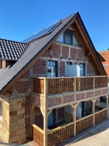 a log home with a deck and a roof at Rehburger Landhaus in Rehburg-Loccum