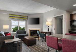 un soggiorno con divano, tavolo e sedie di Hampton Inn & Suites Newport News-Airport - Oyster Point Area a Newport News