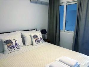 a bedroom with a bed with two bikes on the pillows at John's house in Rhodes Town