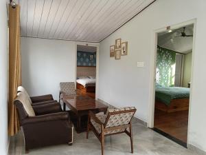 uma sala de estar com um sofá, uma mesa e uma cama em Hill Side Inn em Shimla