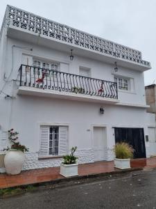 a white house with a balcony with two birds on it at White House - Hospedaje con Desayuno in La Rioja