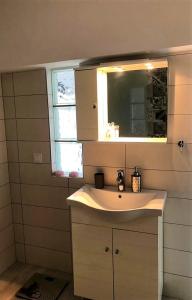 ein Bad mit einem Waschbecken und einem Spiegel in der Unterkunft John's house in Rhodos (Stadt)
