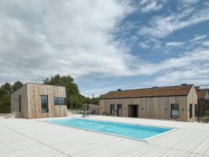 a house with a swimming pool next to a building at Hages Badehotel in Rødby
