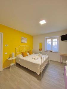 a bedroom with a bed and a yellow wall at Dimora Il Campanile in Chieti
