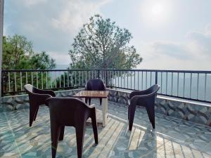 a patio with chairs and a table on a balcony at Hill Side Inn in Shimla