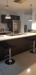 a kitchen with a sink and two bar stools at Maison de Chocolate in Broken Hill