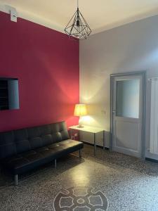 un soggiorno con divano e parete rossa di Centro da Marco a Savona