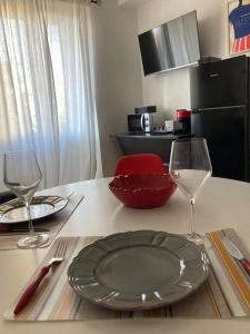 una mesa con un plato y dos copas de vino en Casa Nova Luxury Apartment Suite Limoni, en Nova Milanese
