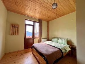 - une chambre avec un lit et un plafond en bois dans l'établissement Hotel Lamala, à Mazeri