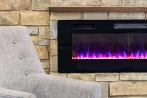 a stone wall with a fireplace with a chair in front at AmericInn by Wyndham La Crosse Riverfront Conference Center in La Crosse
