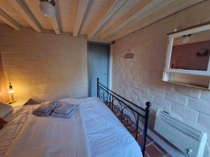 Bett in einem Zimmer mit Ziegelwand in der Unterkunft Bulle ivoire in Hastière-par-delà