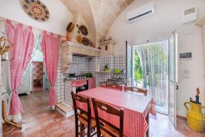 cocina con mesa y mantel rojo en Carbone Country House Oria - Happy Rentals, en Oria