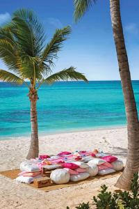 una playa con un montón de tablas de surf y palmeras en Zemi Beach House, LXR Hotels & Resorts, en Shoal Bay Village