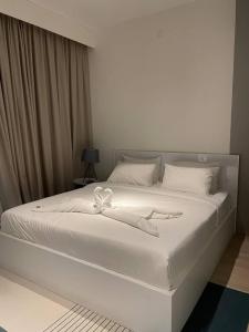 a white bed with a white ribbon on it at Monde Residence K 01 Batam Centre in Nagoya +19 photos