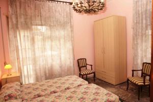 a bedroom with a bed and two chairs and a cabinet at Ipanema B&B in Rome