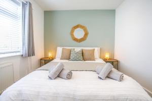 a bedroom with a large white bed with three pillows at Southern - Bracklesham Bay in Chichester