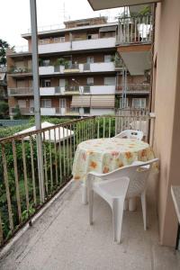 un tavolo e sedie su un balcone con un edificio di Ipanema B&B a Roma