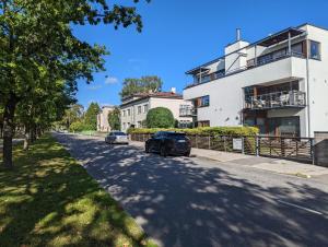 eine Straße mit Autos, die vor einem Gebäude geparkt sind in der Unterkunft Studio Apartment with Sauna in Pärnu