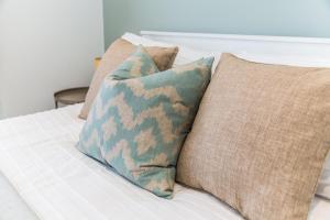 a group of pillows sitting on top of a bed at Southern - Bracklesham Bay in Chichester