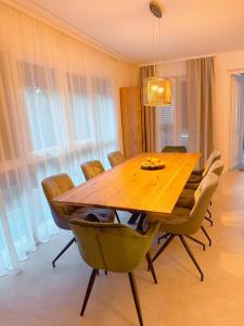 uma sala de jantar com uma mesa de madeira e cadeiras em Villa Sani em Bribir
