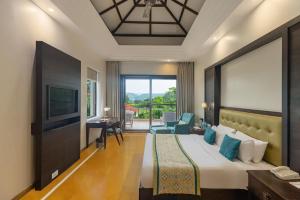 a hotel room with a bed and a television at Mahua Bagh Resort Kumbhalgarh in Kumbhalgarh