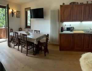 ein Esszimmer mit einem Tisch und Stühlen sowie eine Küche in der Unterkunft Courmayeur~navetta gratuita per il centro+impianti in Courmayeur