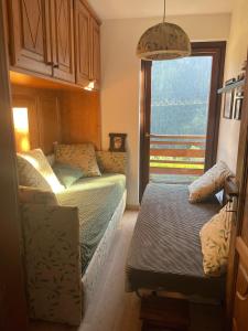 a living room with a couch and a window at Courmayeur~navetta gratuita per il centro+impianti in Courmayeur