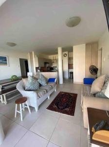 a living room with two couches and a table at Unobstructed sea view gem (1 Spindrift) in St Francis Bay